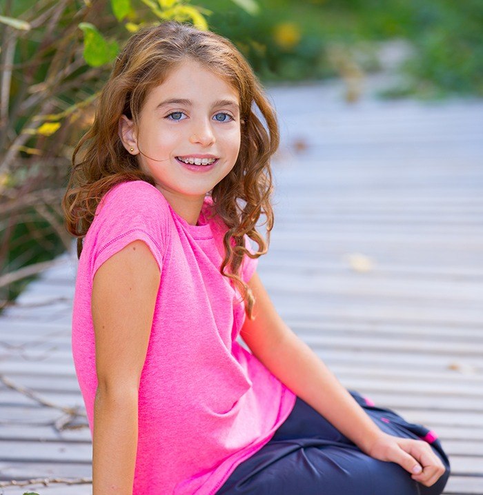 Young girl with orthodontic appliance in place smiling