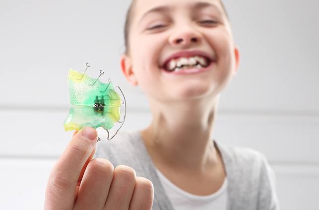 Young woman holding an orthodontic appliance
