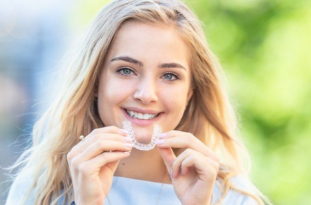 Person holding Invisalign clear braces tray