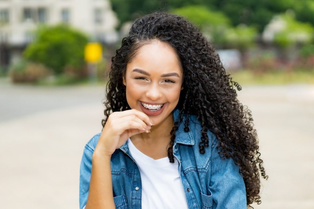 Closeup of woman with braces smiling outside