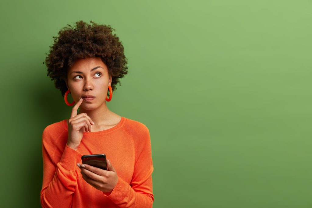 Closeup of woman wondering while checking her phone